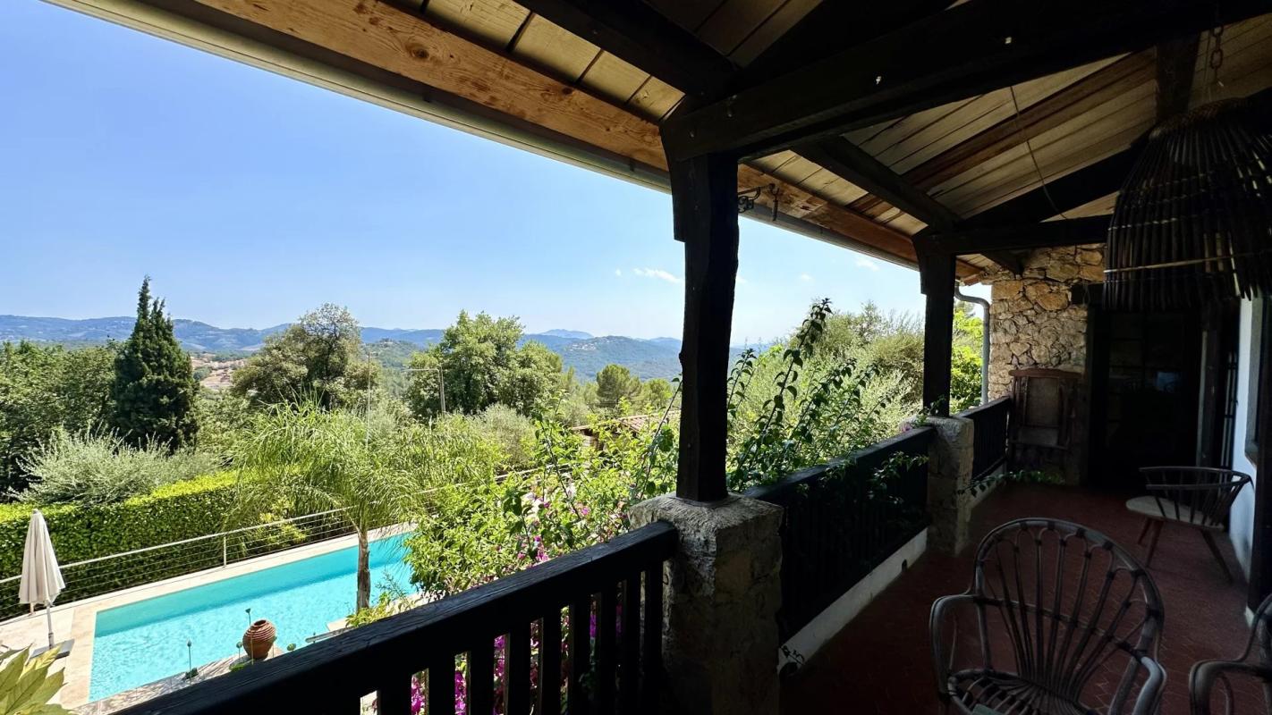 Villa avec vue panoramique et piscine au Tignet Vue de la piscine et du jardin depuis la terrasse d'une villa au Tignet, avec panorama sur les collines provençales.