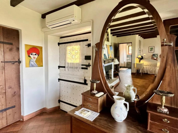 Intérieur d'une villa avec miroir ovale, meuble en bois et décoration artistique.