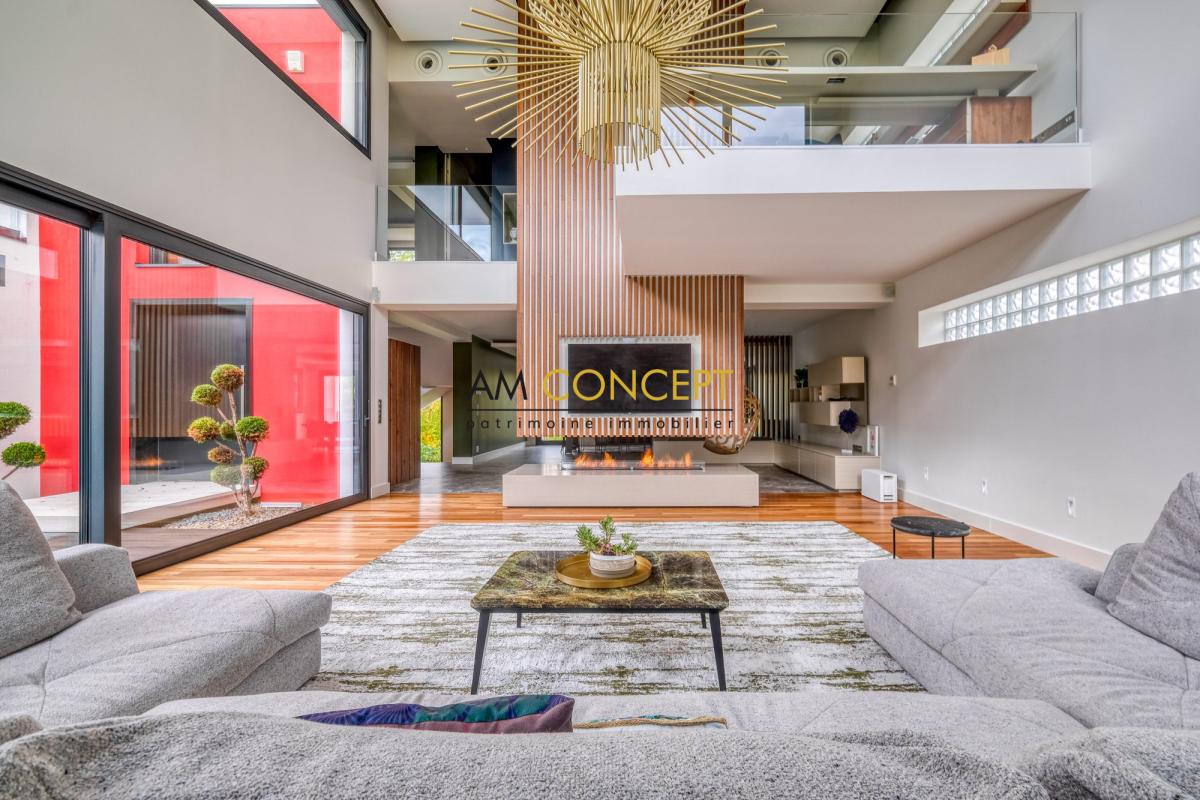 Salon d’une maison d’architecte à Chessy Intérieur d'une maison d'architecte moderne avec salon lumineux et cheminée.