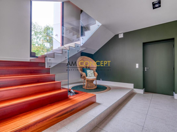 Intérieur d'une maison d'architecte avec un escalier en bois et un coin salon confortable.