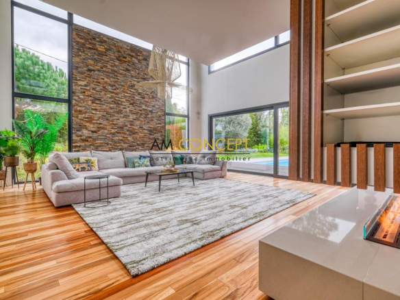 Intérieur d'une maison d'architecte avec un salon moderne, grandes fenêtres et cheminée.