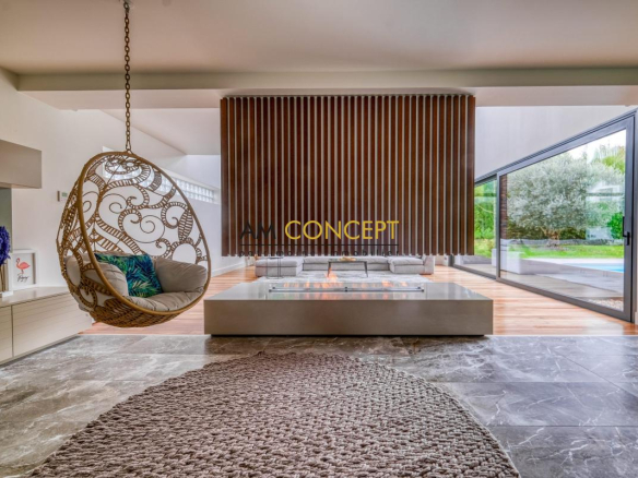 Intérieur d'une maison d'architecte avec un salon moderne et une chaise suspendue.