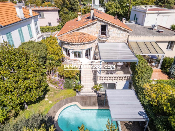 Maison en pierres de taille avec piscine à Nice Mont Boron, entourée de verdure.
