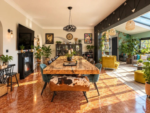 Intérieur d'une villa de plain-pied avec un grand salon et une salle à manger, décorée de plantes.