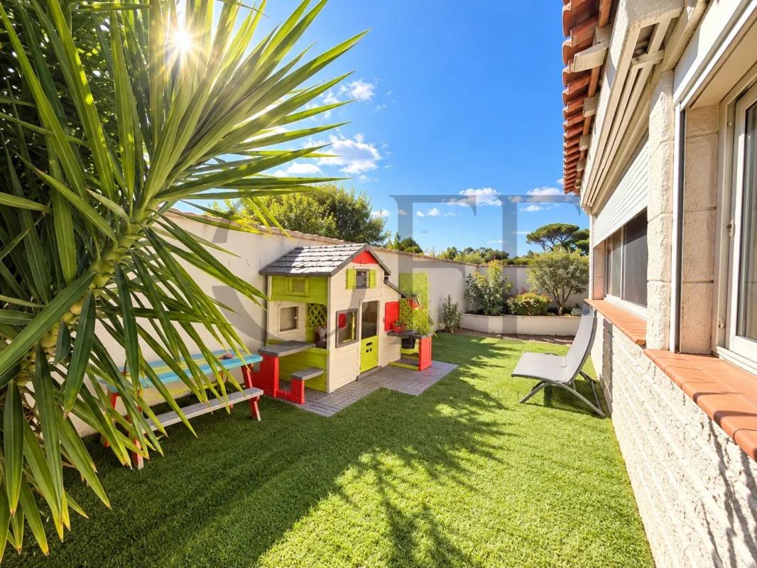 Jardin de la villa à Marseille 13e Jardin d'une villa avec une maison de jeux colorée et un espace vert bien entretenu.