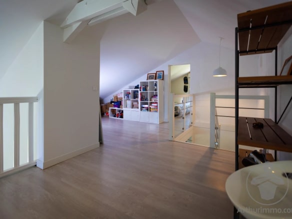 Intérieur d'une maison moderne avec des espaces ouverts et une décoration lumineuse.