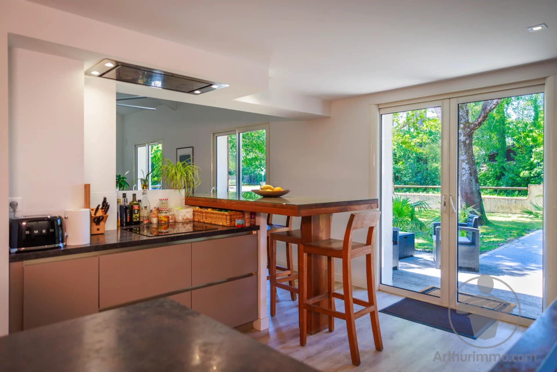 Cuisine moderne avec bar Intérieur d'une maison moderne avec cuisine ouverte et bar, vue sur le jardin.