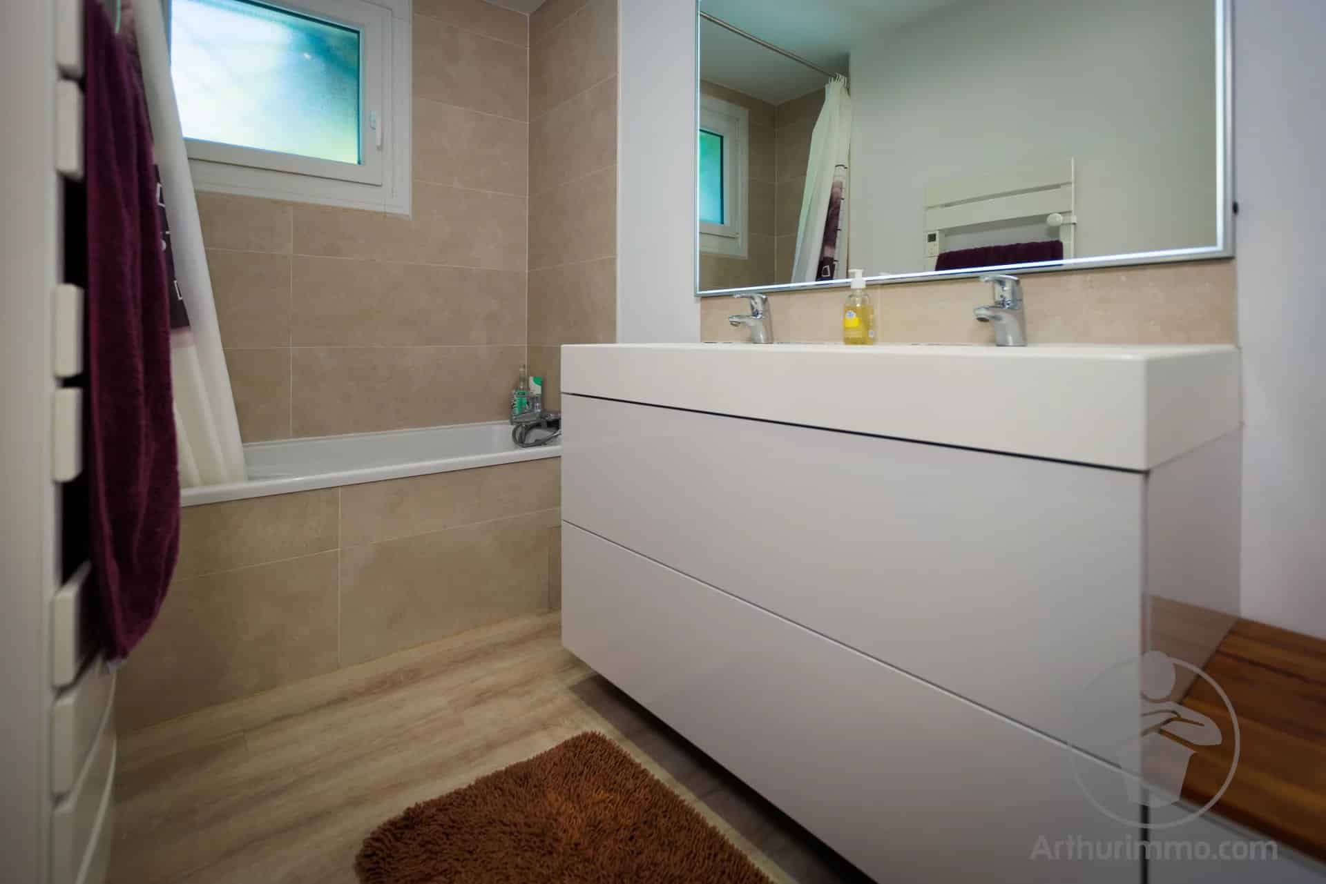 Salle de bain moderne à Sanguinet Salle de bain moderne avec baignoire, lavabo et miroir, dans une maison à Sanguinet.