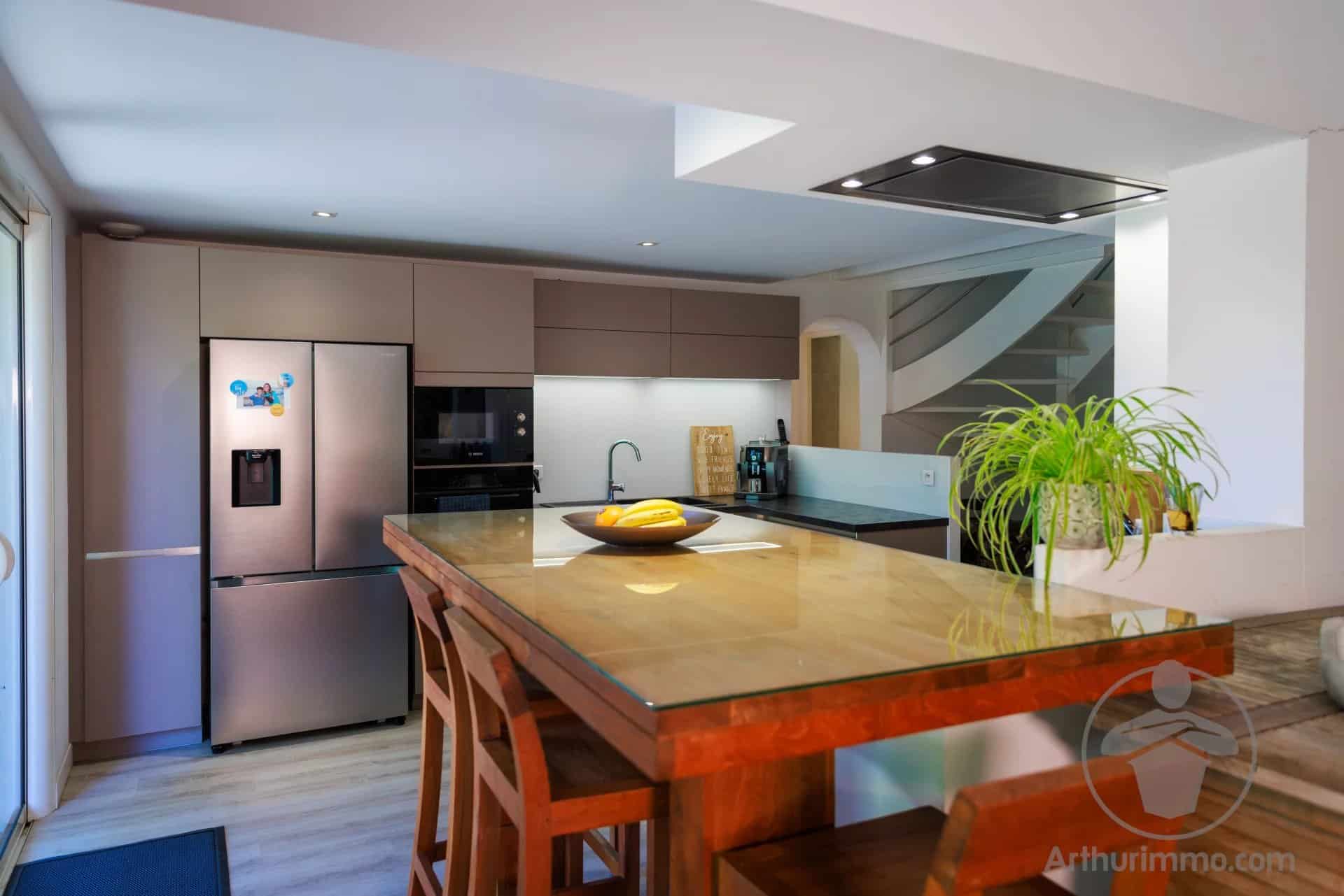 Cuisine spacieuse et moderne Cuisine moderne avec un bar en bois et des appareils électroménagers en inox.