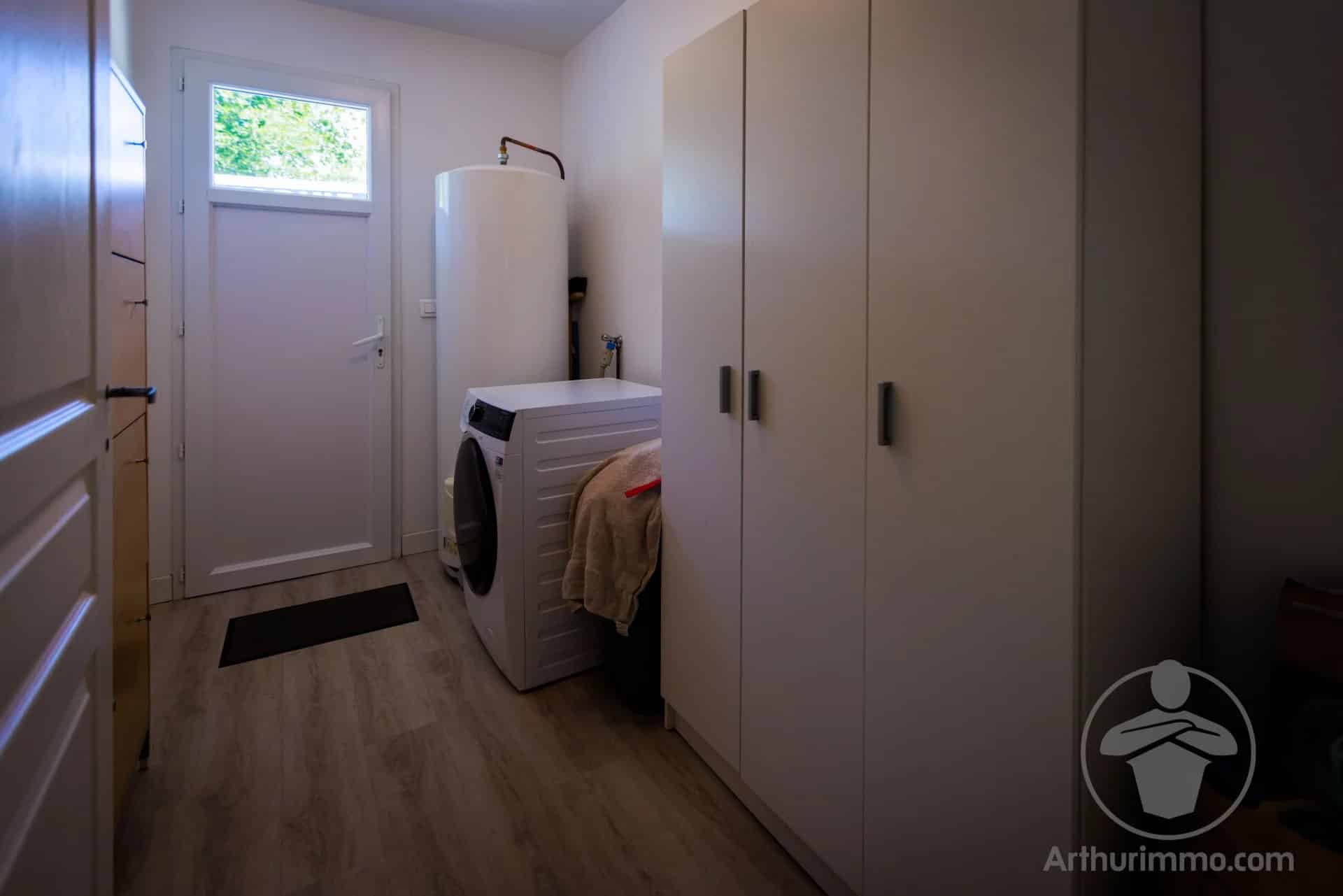 Buanderie d’une maison à Sanguinet Intérieur d'une maison avec une buanderie, machine à laver et rangements.