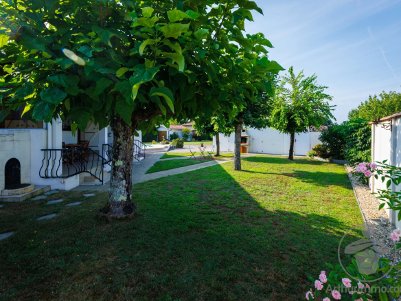 Garden with trees and green space in a property in Parentis-en-Born.