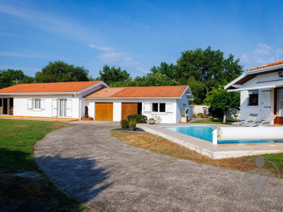 Property in Parentis-en-Born with two houses, swimming pool and 2,063 m² of land under a blue sky.
