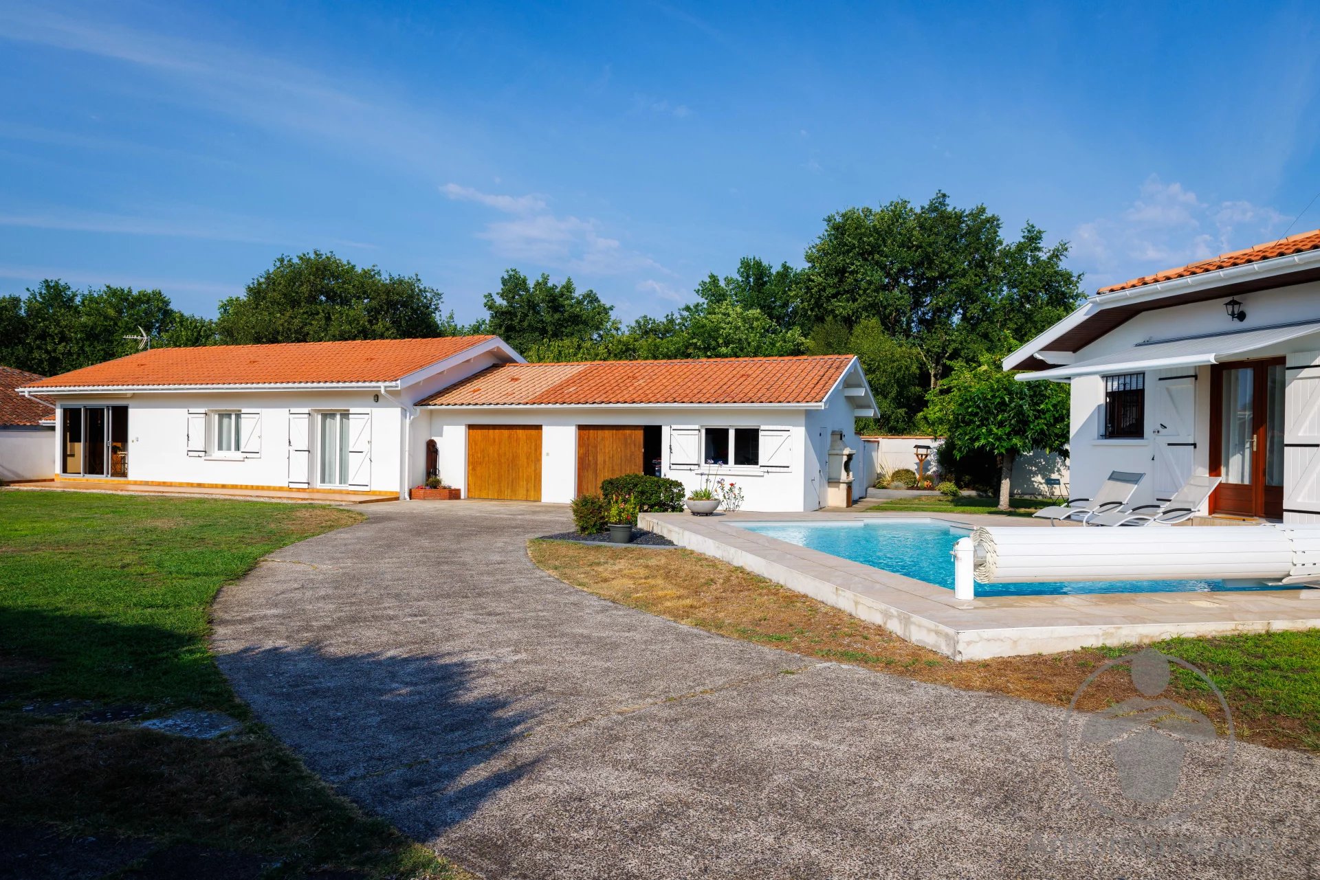 Property in Parentis-en-Born with two houses, swimming pool and 2,063 m² of land under a blue sky.