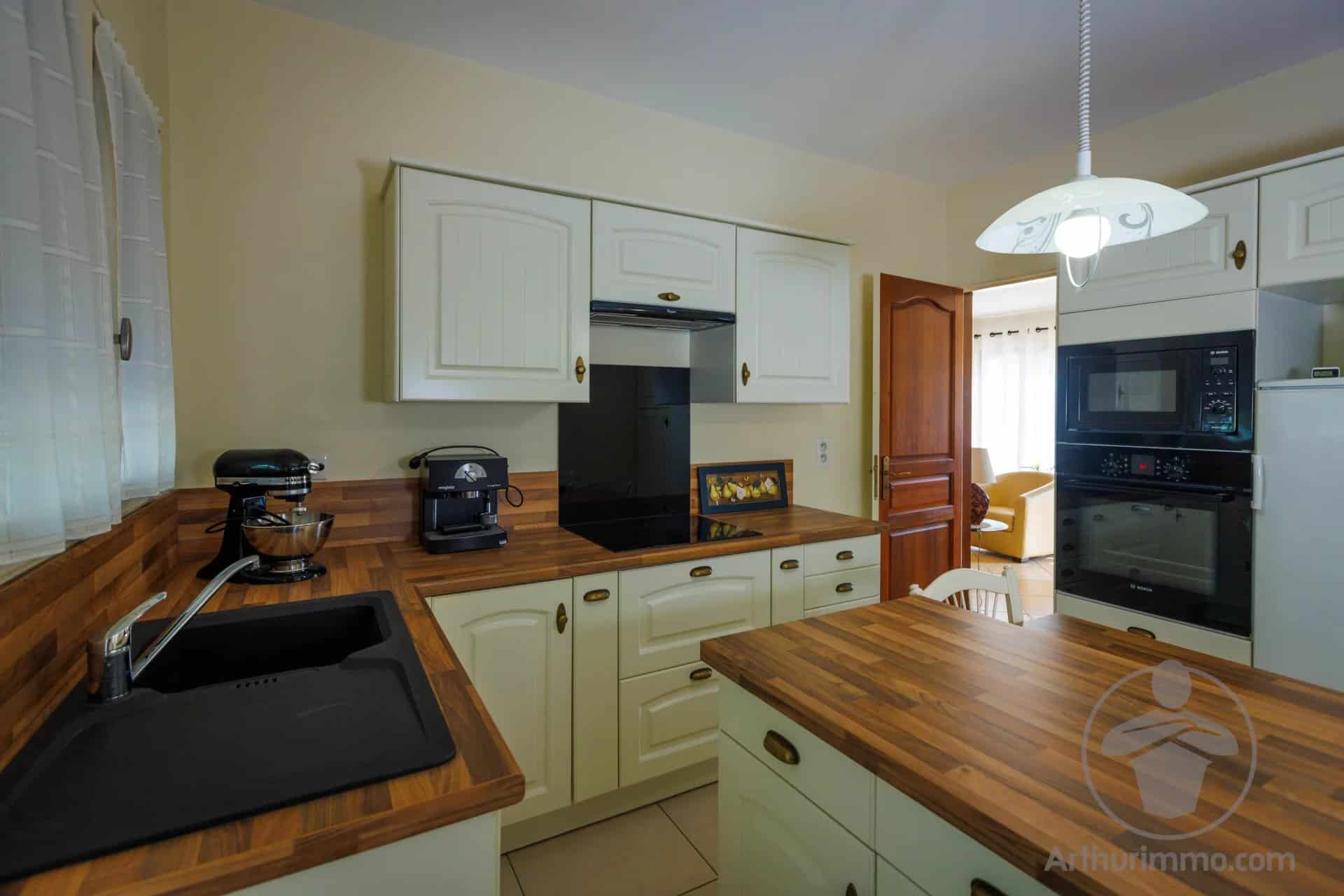 Modern kitchen with wooden furniture and integrated appliances.