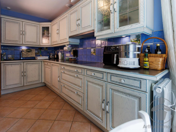 Kitchen of a house in the Landes region with light wood furniture and beige tiles.