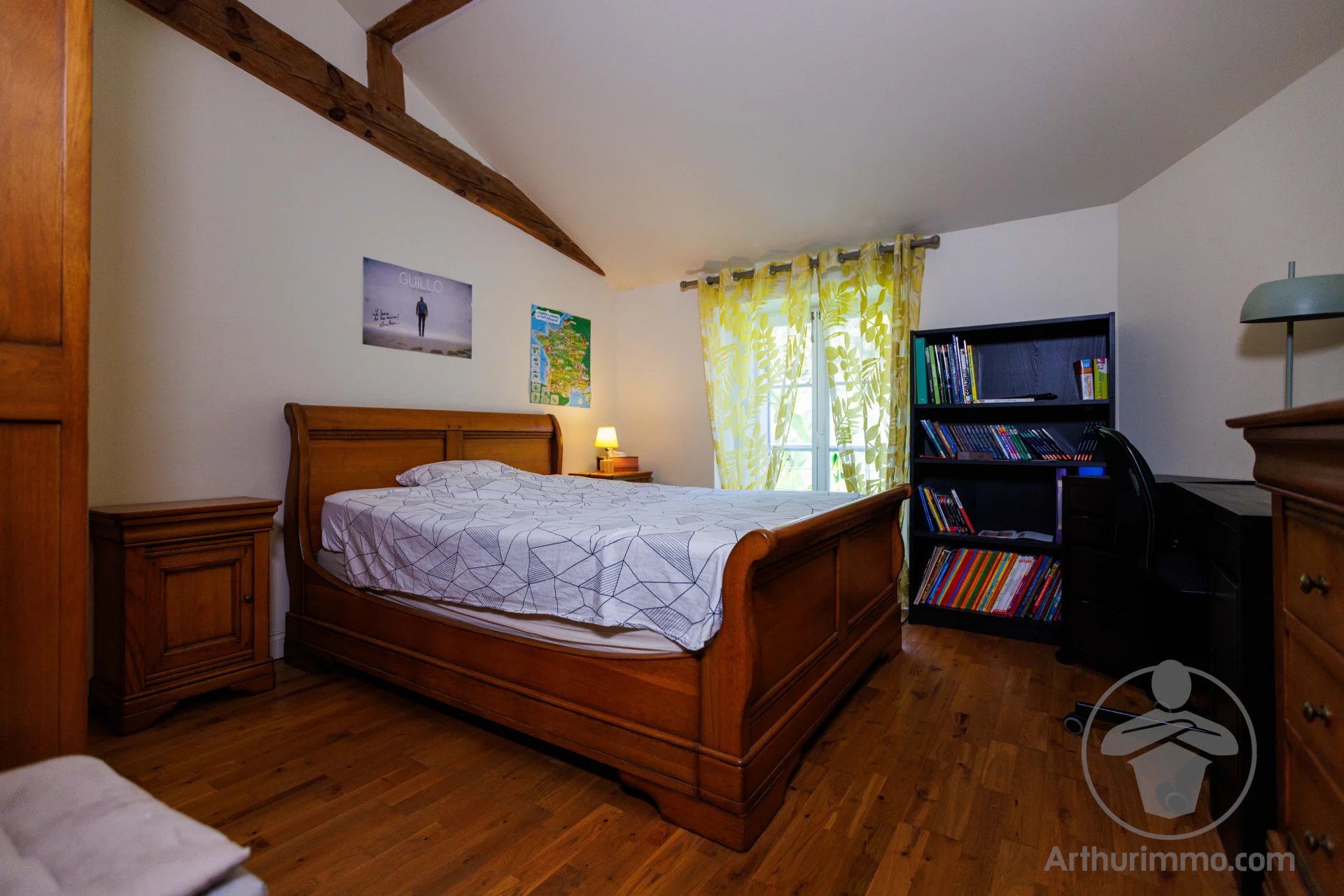 Bed and breakfast in a character property Bedroom in a house with a wooden bed, desk and shelves, decorated in a simple style.