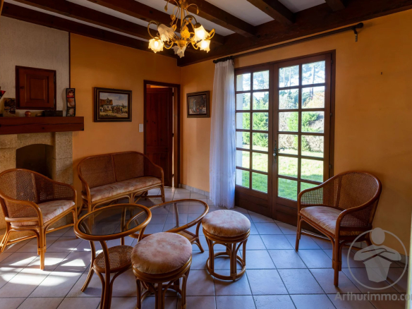 Intérieur d'une maison familiale à Biscarrosse Plage avec salon lumineux et mobilier en rotin.