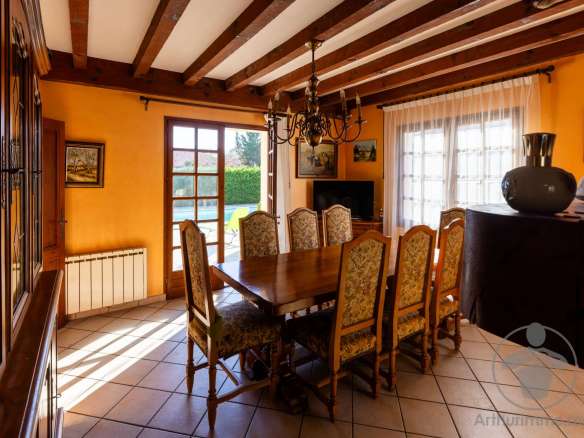 Intérieur d'une maison familiale à Biscarrosse Plage, salle à manger avec table et chaises en bois.