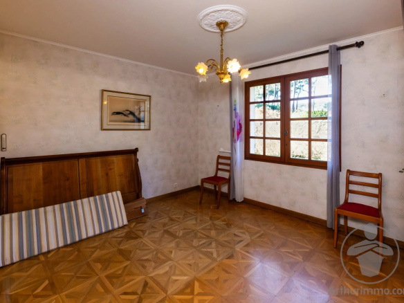 Intérieur d'une maison familiale à Biscarrosse Plage avec parquet et fenêtres en bois.