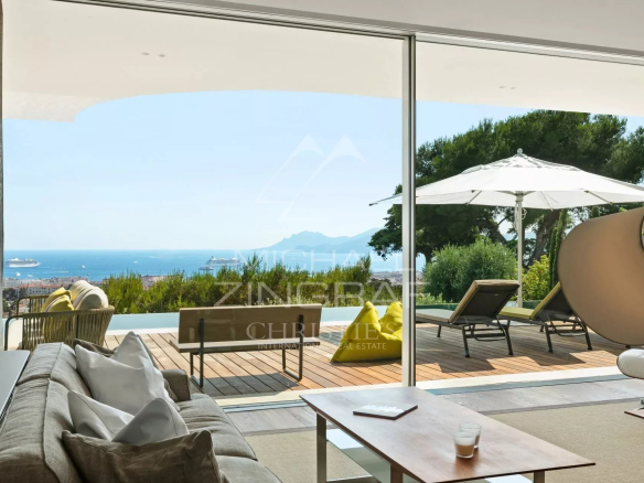 Intérieur d'une villa moderne à Cannes avec vue sur la mer et accès à une terrasse.