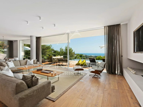 Intérieur moderne d'une villa à Cannes avec salon lumineux et vue sur la mer.
