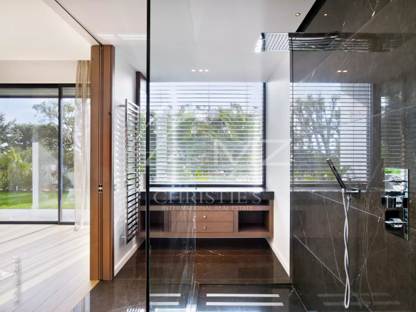 Salle de bain moderne avec douche et vue sur le jardin, propriété contemporaine à Cannes.