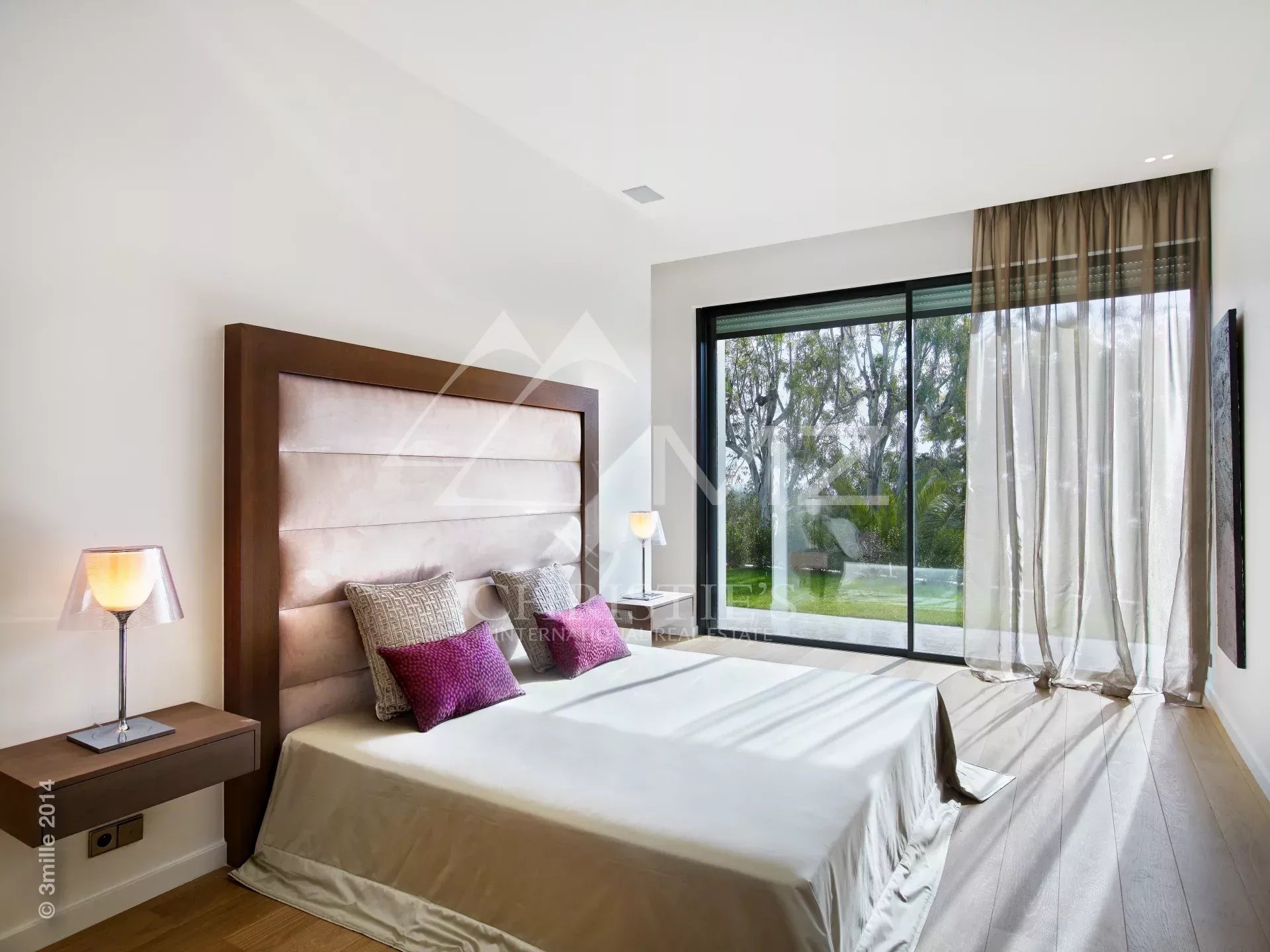 Chambre contemporaine à Cannes Chambre moderne avec lit king-size et grandes fenêtres donnant sur un jardin.