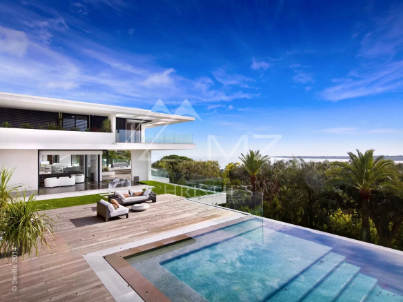 Propriété contemporaine avec piscine et vue sur la baie de Cannes, entourée de verdure.