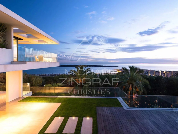 Vue d'une propriété contemporaine avec piscine et jardin à Cannes, surplombant la baie et les Iles de Lérins.