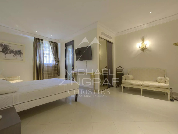 Chambre d'un hôtel particulier à Cannes, avec lit, télévision et canapé.