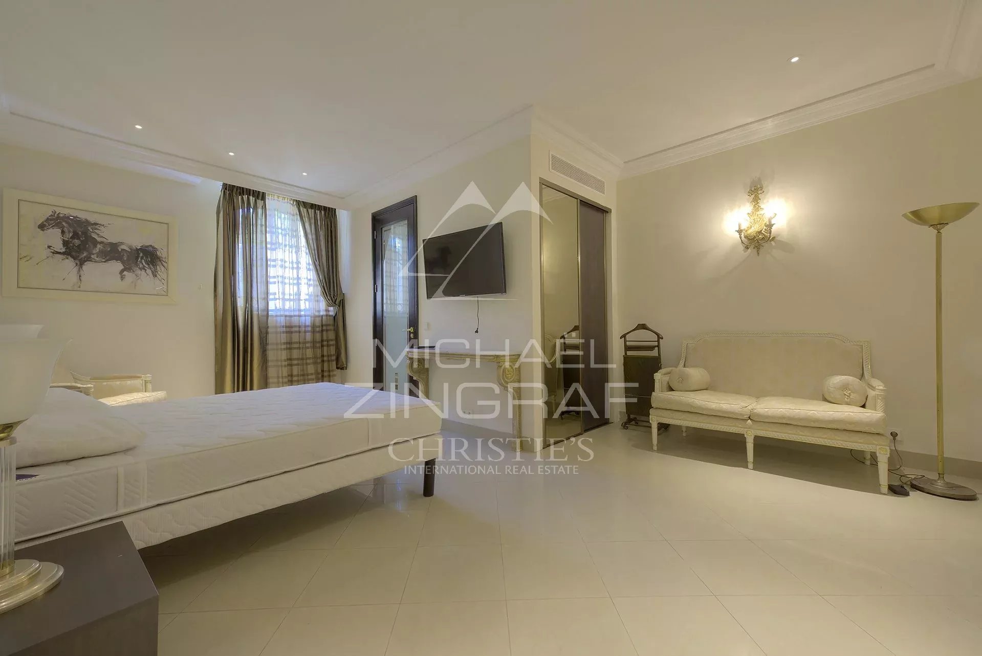 Chambre d’hôtel particulier à Cannes Chambre d'un hôtel particulier à Cannes, avec lit, télévision et canapé.