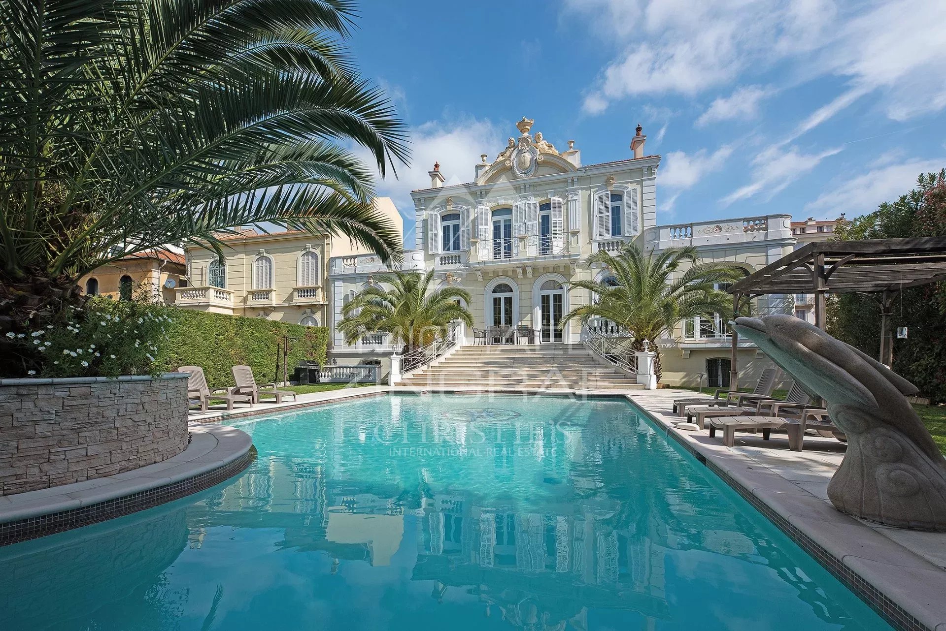 Hôtel particulier à Cannes Hôtel particulier à Cannes avec piscine et palmiers, architecture élégante.