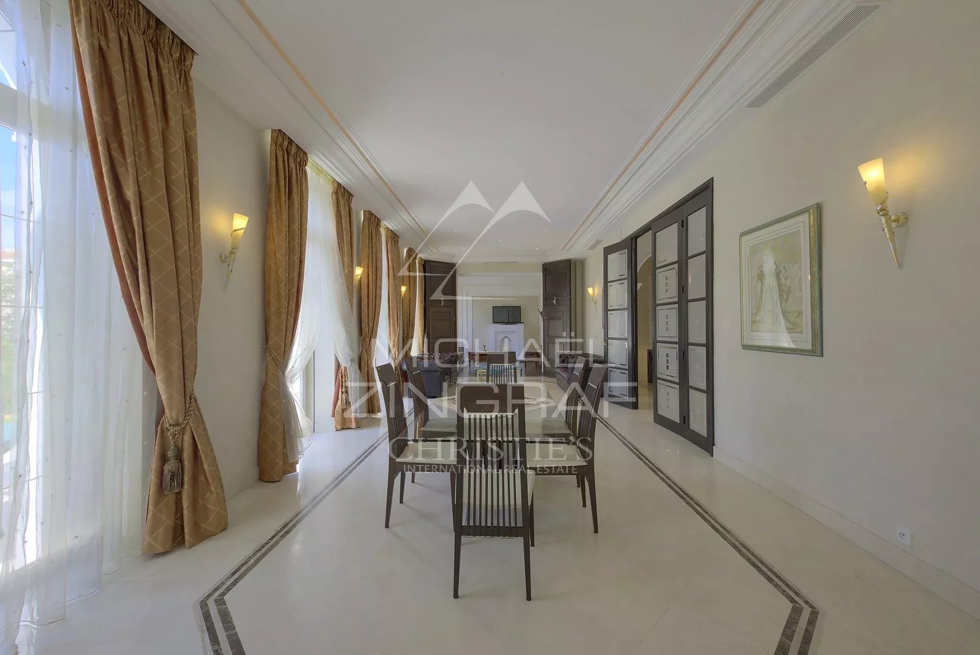 Intérieur d’un hôtel particulier à Cannes Intérieur d'un hôtel particulier à Cannes avec salle à manger élégante et baies vitrées.