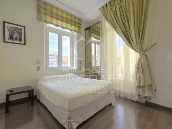 Chambre d'un hôtel particulier à Cannes avec fenêtres et lit.