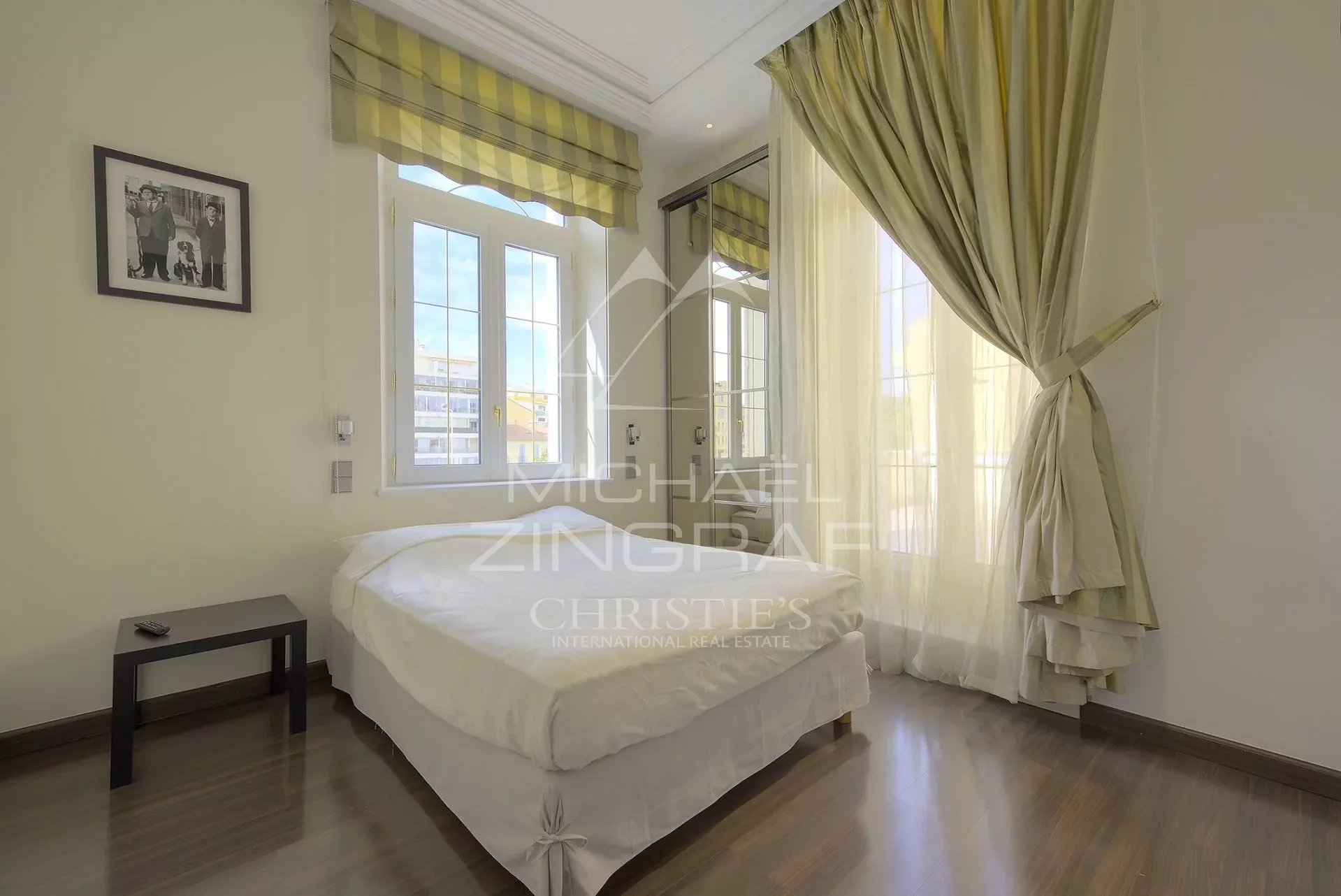 Chambre d’hôtel particulier à Cannes Chambre d'un hôtel particulier à Cannes avec fenêtres et lit.