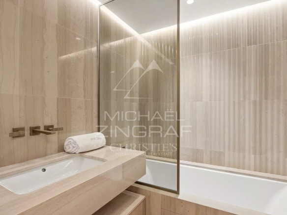 Modern bathroom with marble bathtub and sink.