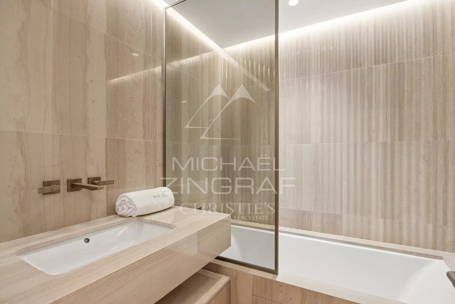 Bathroom of a luxury apartment in Cannes Modern bathroom with marble bathtub and sink.