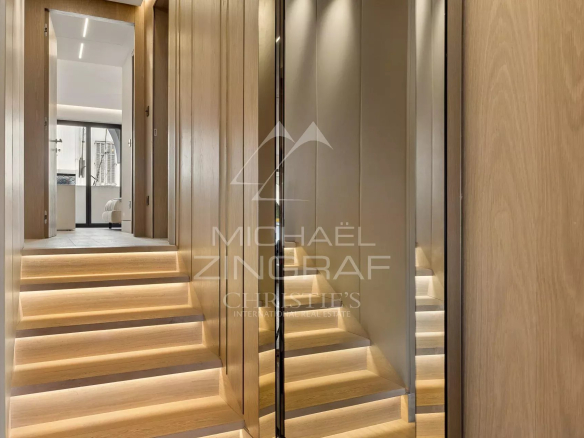 Interior of a luxury apartment with a wooden staircase and mirrored walls in Cannes.