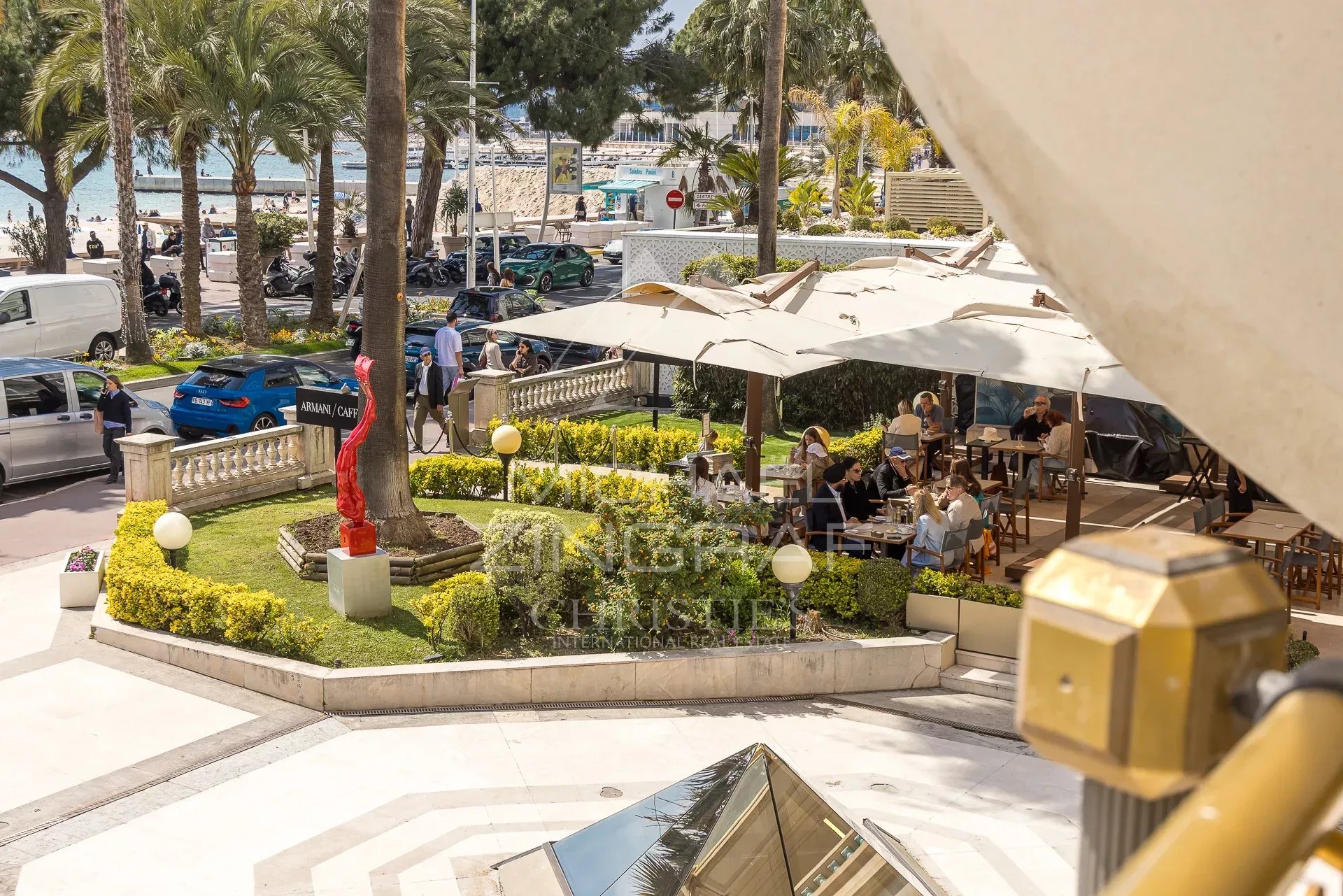 Terrace on the Croisette in Cannes Restaurant terrace on the Croisette in Cannes with views of the sea and palm trees.