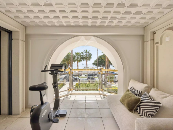 Interior of an apartment in Cannes with sea view, including a living area and an exercise bike.