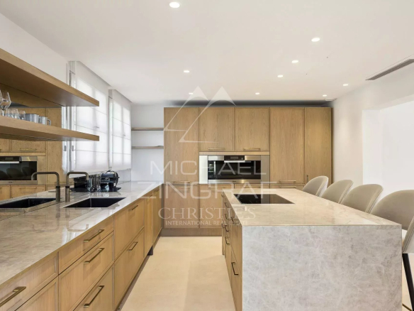 Cuisine moderne avec îlot central et rangements en bois dans une villa