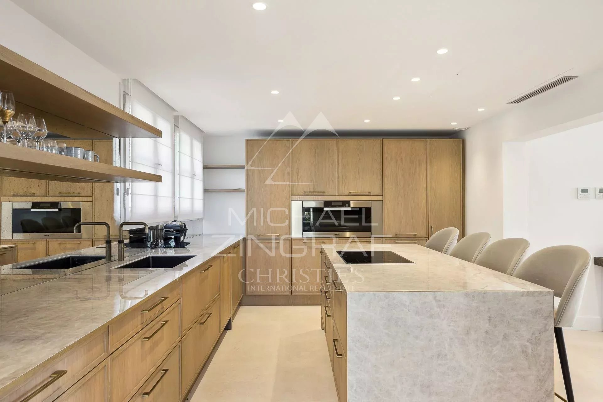 Cuisine moderne de villa à Vallauris Cuisine moderne avec îlot central et rangements en bois dans une villa