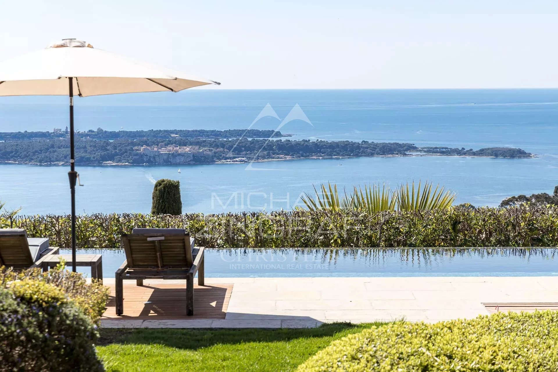 Villa moderne avec vue mer à Vallauris Vue panoramique sur la mer depuis une villa avec transats et piscine à Vallauris.