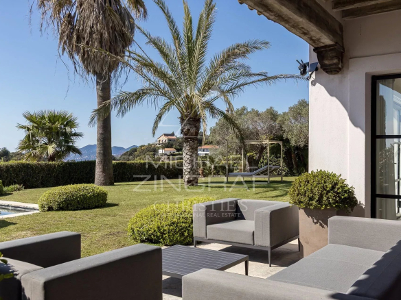 Vue d'un jardin avec piscine et mobilier extérieur dans une villa moderne à Vallauris.