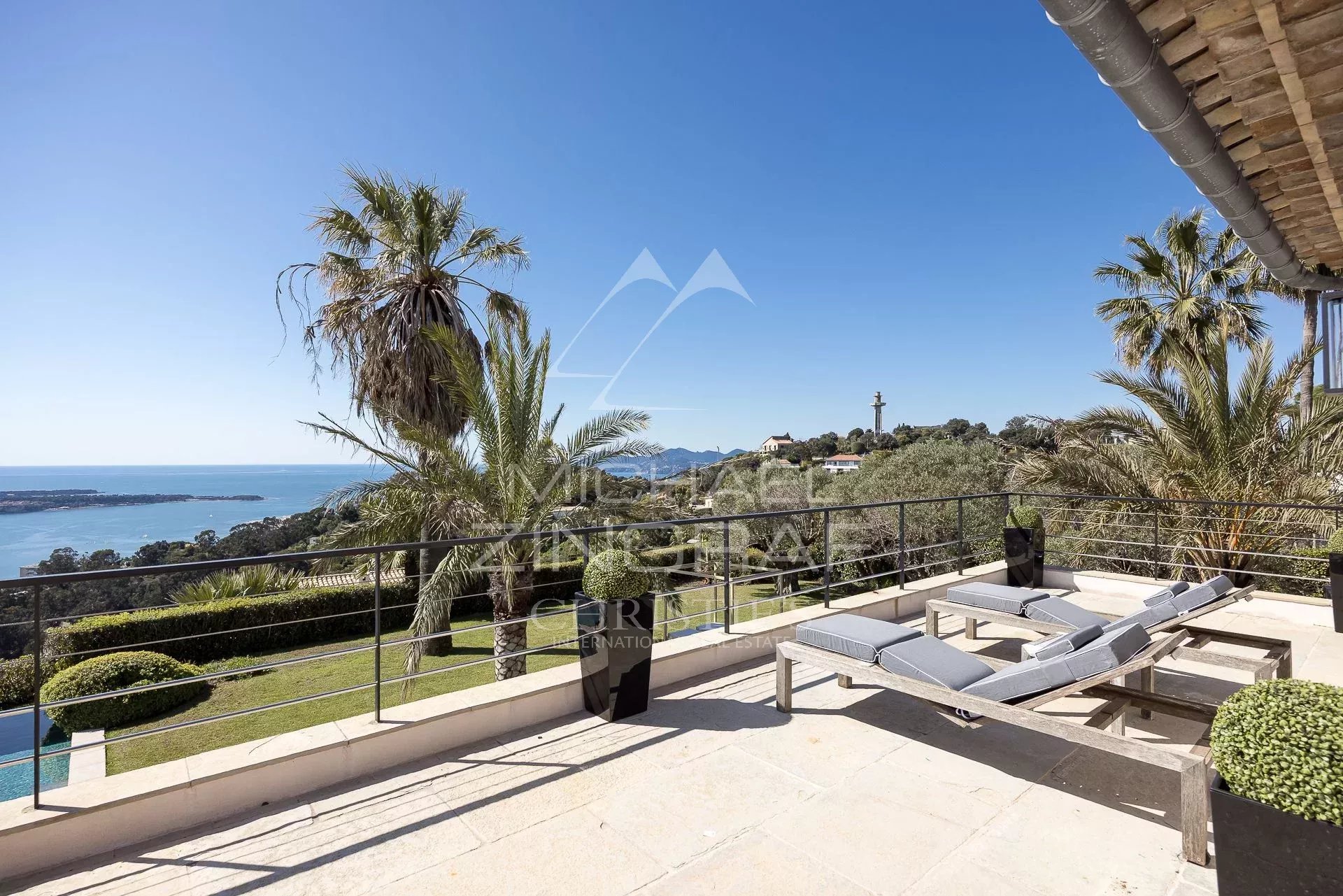 Villa avec vue mer à Vallauris Terrasse de villa avec vue panoramique sur la mer, entourée de palmiers et de verdure à Vallauris.