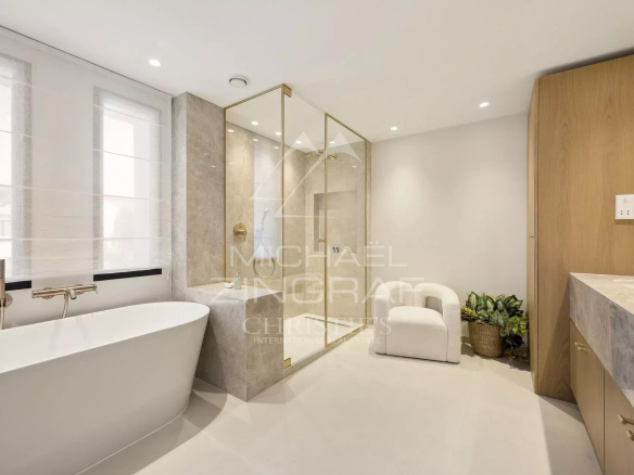 Salle de bain moderne avec baignoire et douche en verre dans une villa à Vallauris.