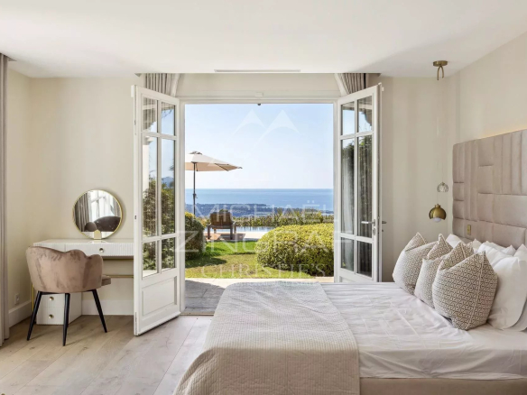 Chambre moderne avec vue sur la mer et accès à un jardin.