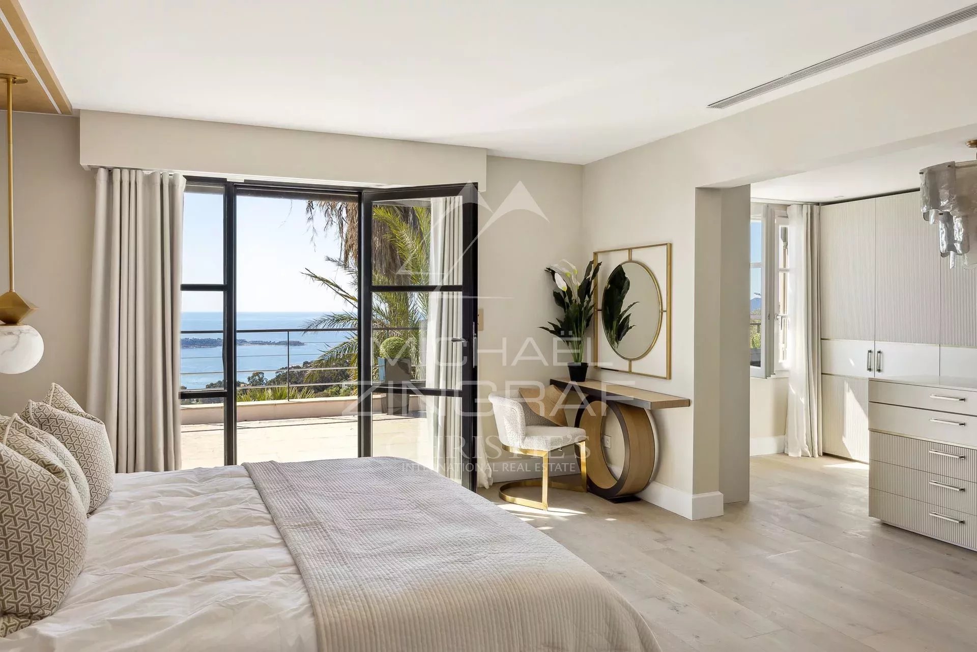 Chambre avec vue mer à Supercannes Chambre lumineuse avec vue sur la mer, décor moderne, fenêtres ouvertes sur l'extérieur.