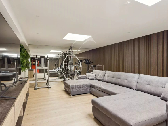 Salle de sport moderne avec équipements et canapé dans une villa à Vallauris.