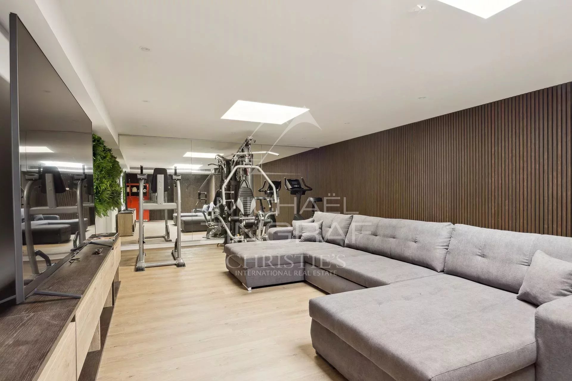 Salle de sport dans une villa à Vallauris Salle de sport moderne avec équipements et canapé dans une villa à Vallauris.
